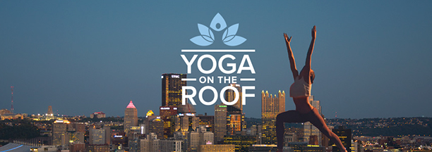 Image of a person doing yoga this the Pittsburgh Skyline in the background